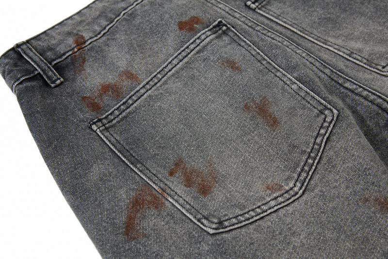Close-up of the back pocket on gray cargo jeans with brown paint splatter