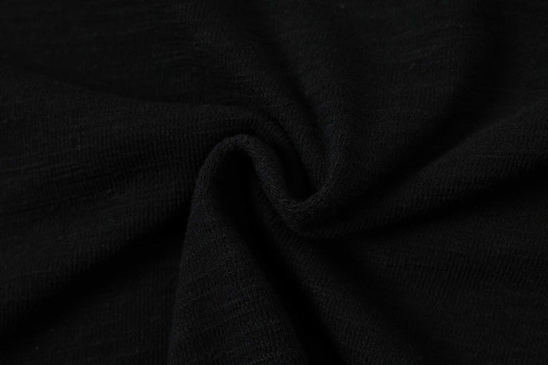 Close-up of black textured fabric with subtle stripe detail, highlighting the Seakoff script stripe polo tee material