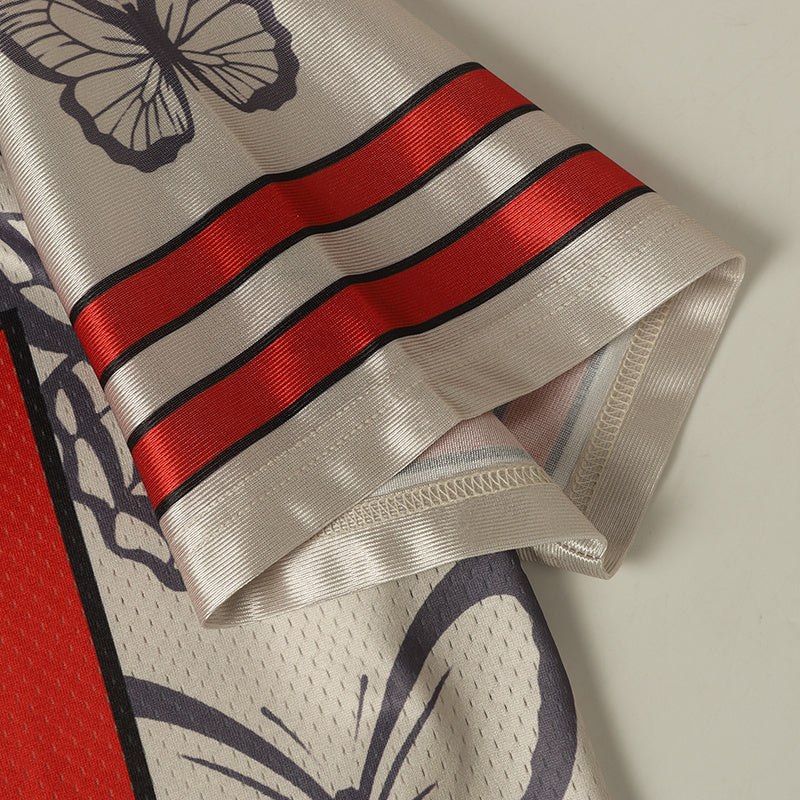 Close-up of a butterfly graphic football jersey sleeve with red striped trim and silver mesh fabric for varsity streetwear style