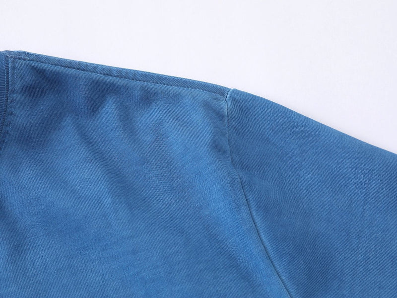 Close-up of a blue streetwear T-shirt sleeve and shoulder seam in soft cotton knit fabric
