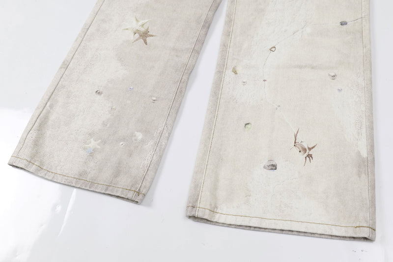 Close-up of lower legs on washed botanical print jeans with starfish and shell graphics