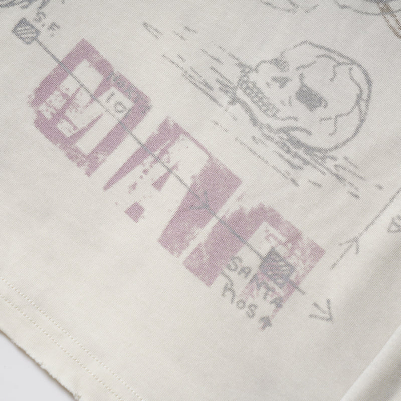 Close-up of purple graphic text and a sketched face on cream long sleeve tee