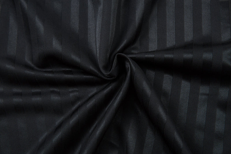 Close-up of black jersey fabric with vertical stripe texture and gathered folds