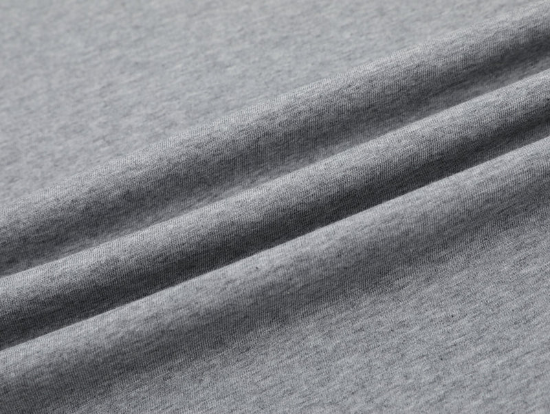 Close-up of heather gray cotton tee fabric with soft folds and a smooth streetwear oversized fit