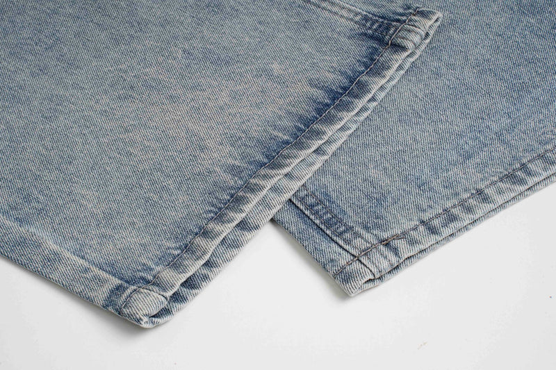 Close-up of light wash jeans hem with stitched cuff