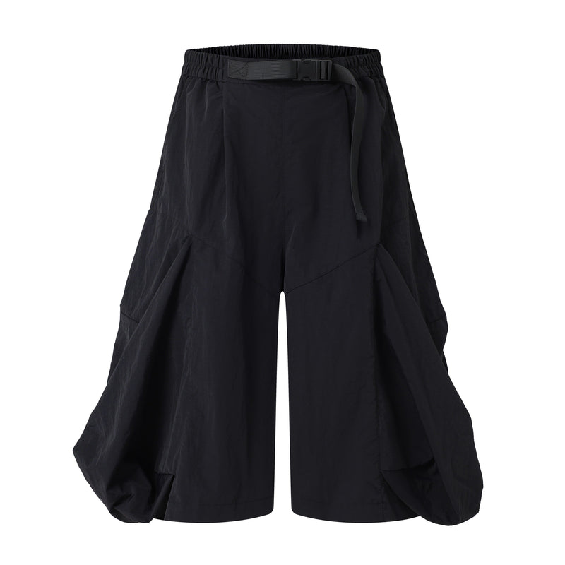 Black wide-leg shorts with elastic waistband, buckle belt, and draped panels, front view