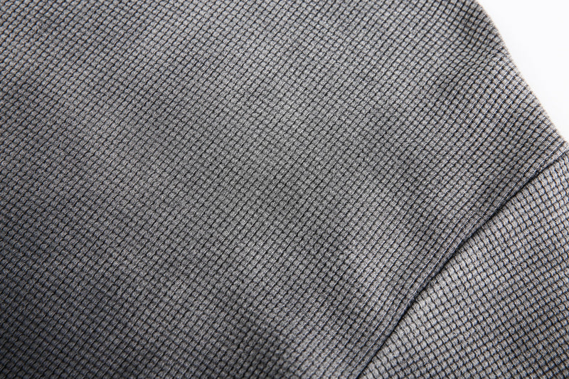 Close-up of gray-black waffle knit fabric texture on the shoulder seam