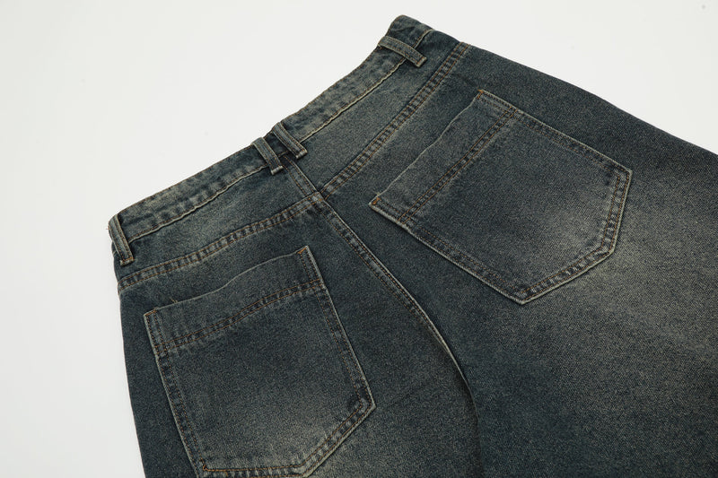 Close-up of the back waistband and pockets on dark wash denim shorts with contrast stitching