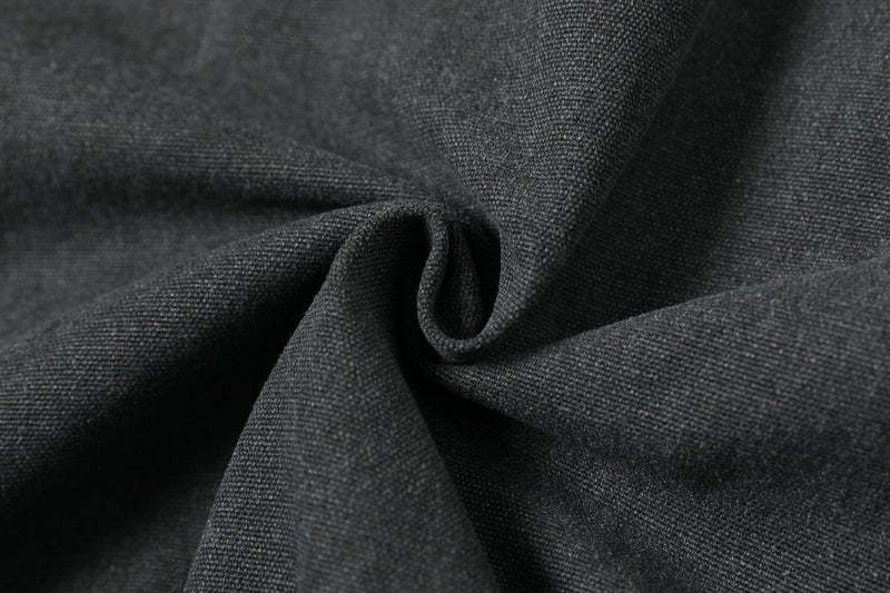 Close-up of black jacket fabric folds showing textured woven material