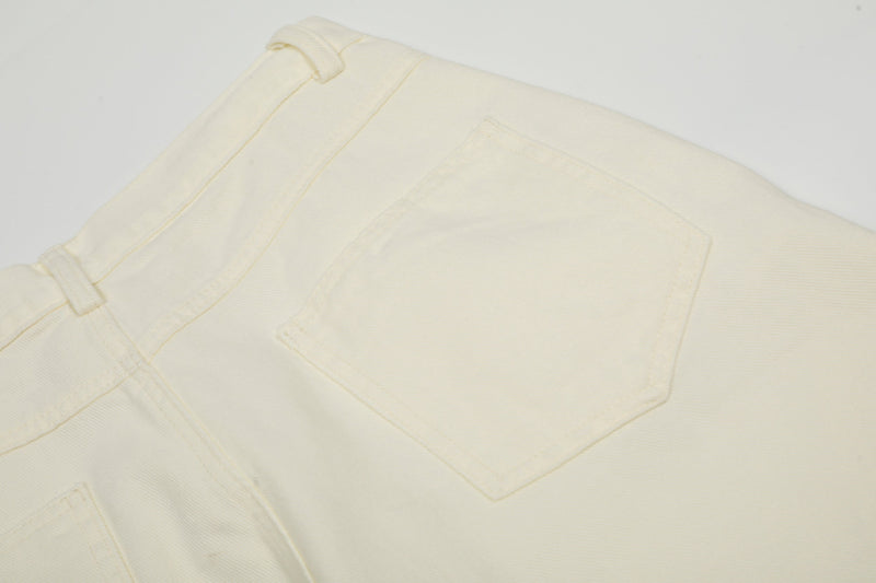 Close-up of cream cargo pants back pocket panel and seam stitching