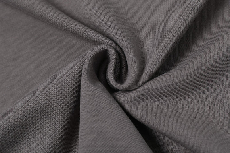 Close-up of gray textured colorblock T-shirt fabric with soft folded knit details and streetwear style texture