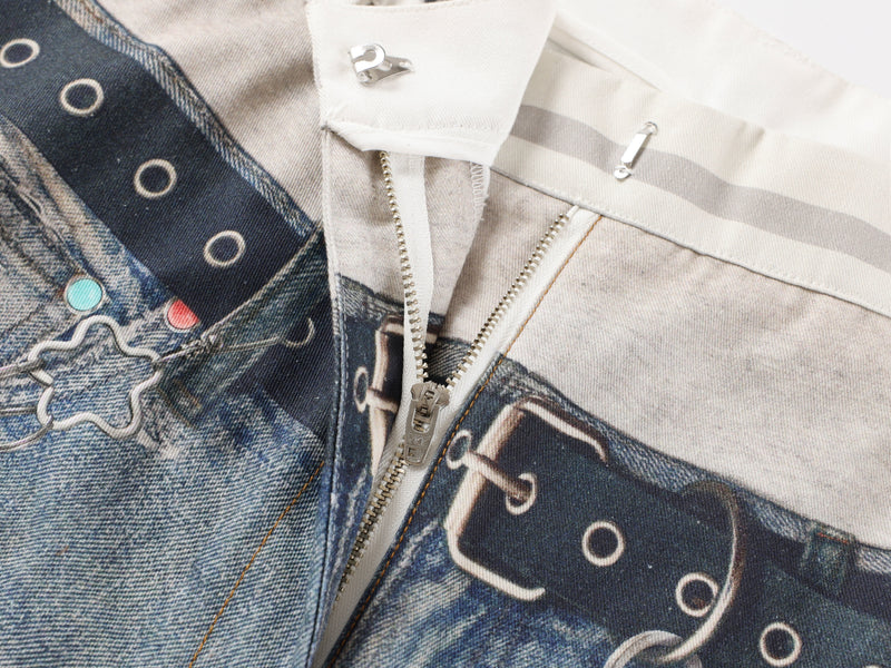 Close-up of center front zipper and waistband on printed distressed denim jeans