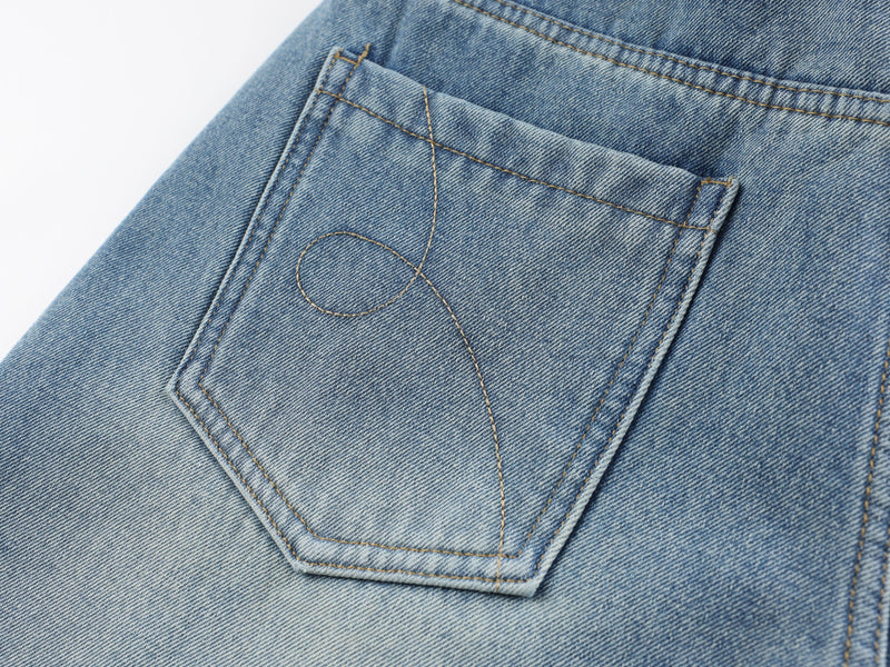 Back pocket detail on light blue denim pants with stitching