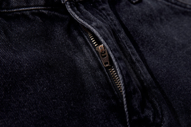 Close-up of front fly zipper on dark wash denim jeans