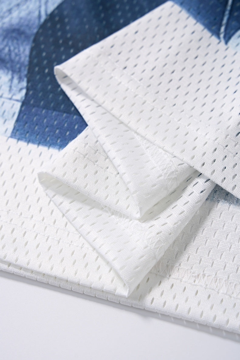 White mesh athletic jersey fabric with folded sleeves and blue graphic accents, showing breathable streetwear texture