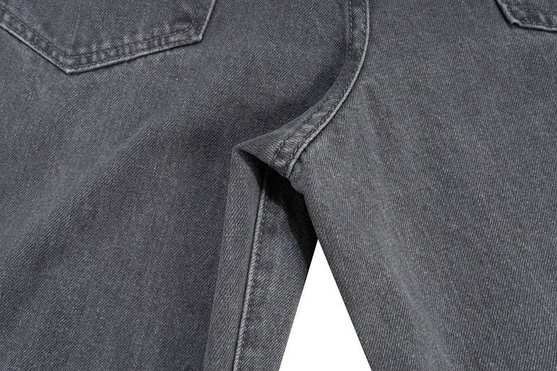 Close-up of grey denim pants showing side seam, front pocket edge and wide leg fit