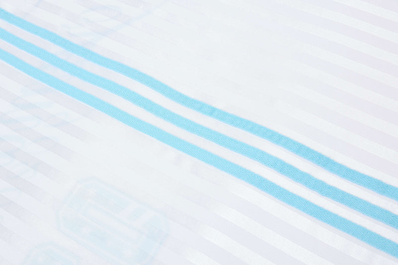 Close-up of white football jersey fabric with diagonal sky blue script stripes and subtle textured pattern
