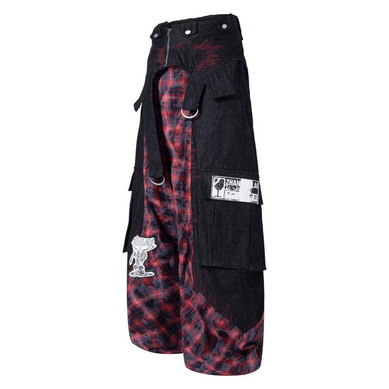 Side view of black cargo pants with red plaid inset panels, flap pockets, and metal ring detail