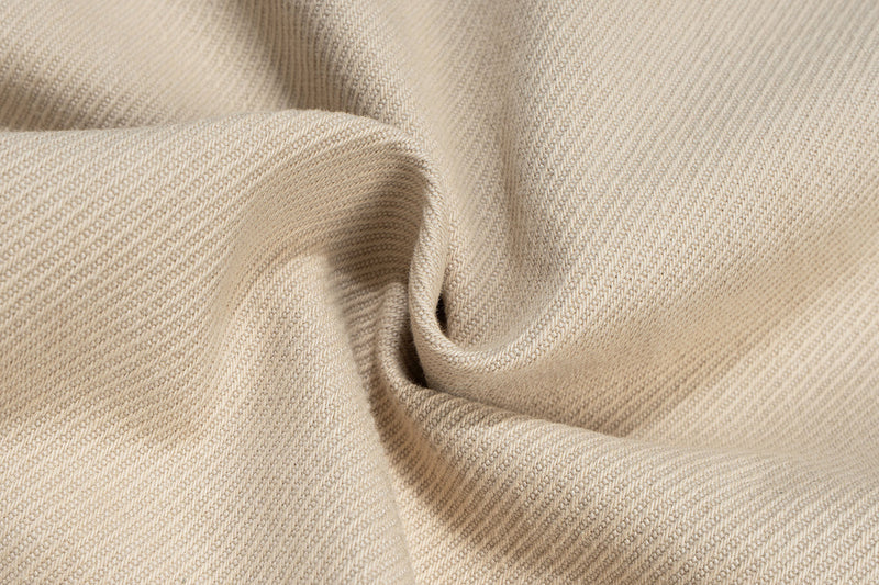 Close-up of beige twill fabric texture with soft folds