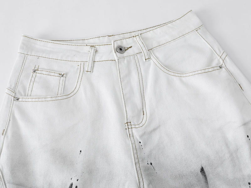 Close-up of the front waistband and pockets on white denim shorts with light brown stitching