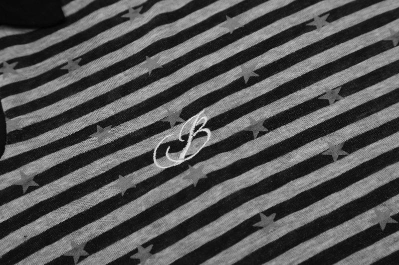 Close-up of chest logo on black striped polo with star print
