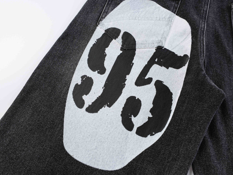 Close-up of black denim graphic print with bold black lettering on white panel
