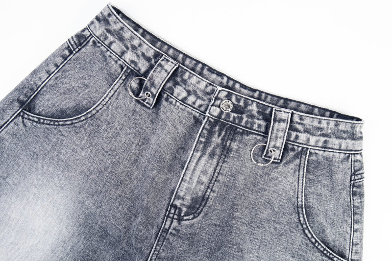 Close-up of denim waistband and pocket with ring hardware and faded gray wash