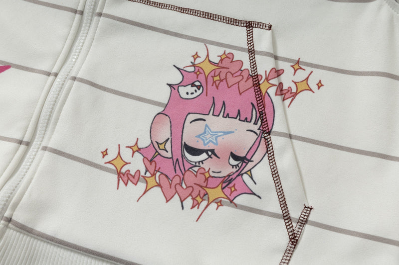 Close-up of pink cartoon face graphic and heart details on cream hoodie