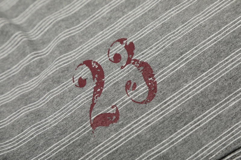 Close-up of red graphic print on gray striped tee with worn distressed finish