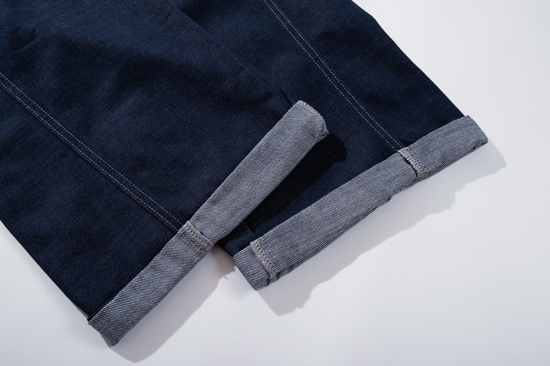 Close-up of rolled cuff hem on deep-indigo wide-leg jeans
