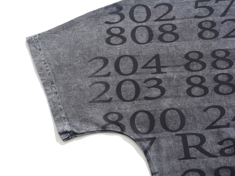 Close-up of a gray vintage wash oversized graphic tee with large dark numeric print and stitched sleeve detail