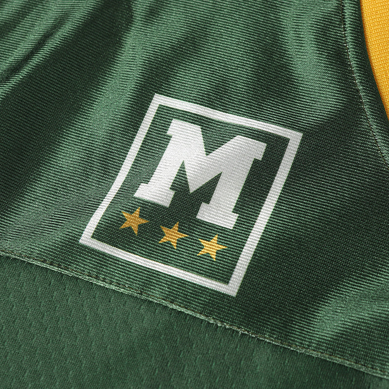 Close-up of a green varsity football jersey with a white M logo and three gold stars on the chest