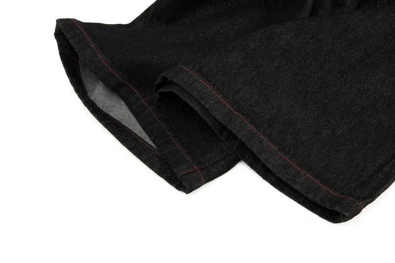 Close-up of black denim cuff hem with contrast red stitching