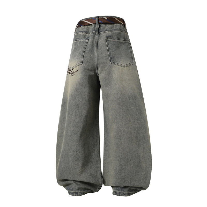 Back view of wide-leg vintage wash denim pants with striped tie waist