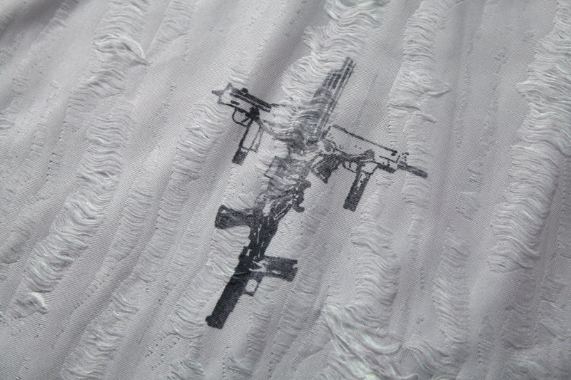 Distressed black rifle graphic on a white textured mesh patchwork tee, close-up detail of the fabric texture