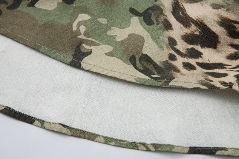 Curved hem close-up showing layered camo shirt over white undershirt
