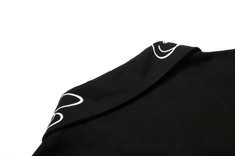 Black cotton polo tee with white star print detail on the shoulder, shown in a close-up on a clean white background