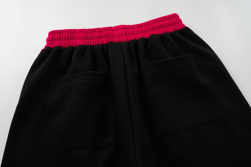 Back close-up of black shorts with magenta waistband and two rear pockets