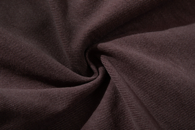 Close-up of brown denim fabric texture with gathered folds