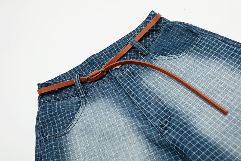 Diagonal close-up of waistband and belt on blue washed grid denim shorts