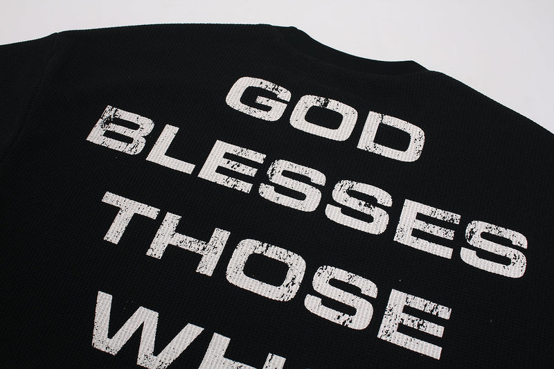Back graphic close-up on black waffle knit sweatshirt with white distressed text