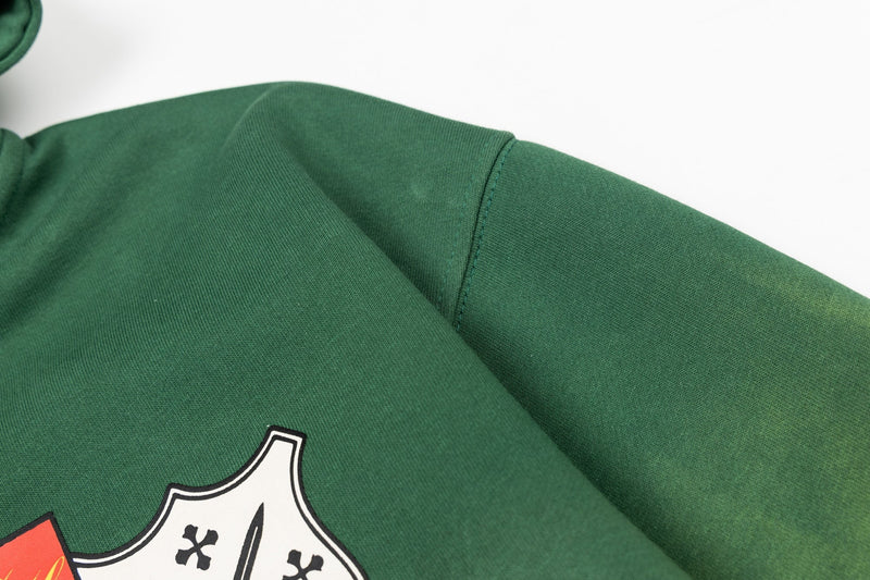 Close-up of green hoodie shoulder and sleeve seam with faded wash texture