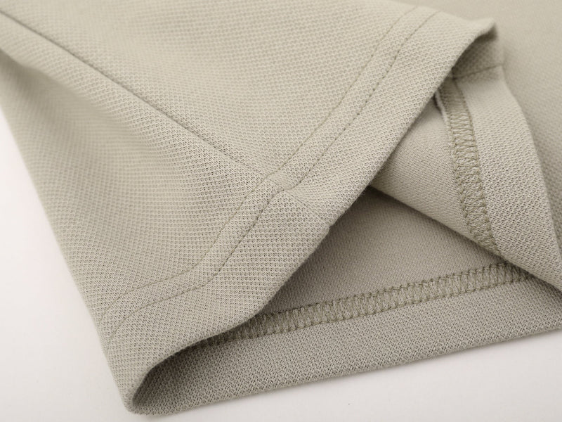 Close-up of beige sleeve hem stitching on the sweatshirt