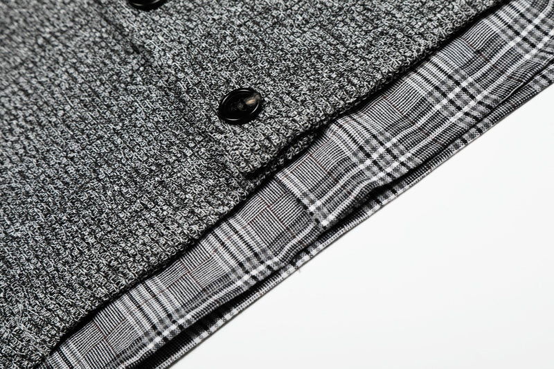 Close-up of a layered knit check shirt with textured gray fabric, black button, and plaid cotton trim