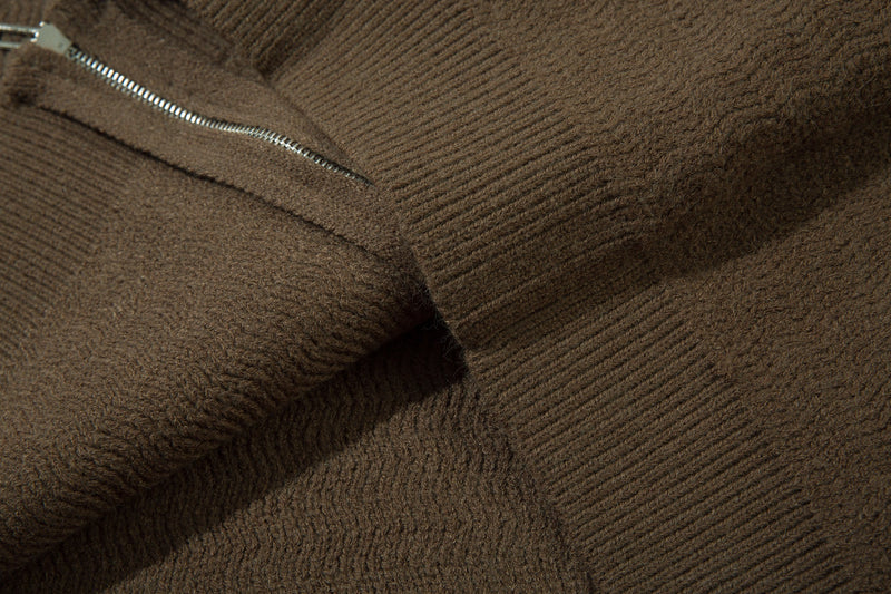 Close-up of brown knit hoodie fabric with visible zipper and ribbed texture