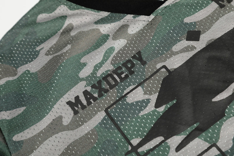 Close-up of green and gray camo mesh jersey fabric with MAXDEPOT logo detail