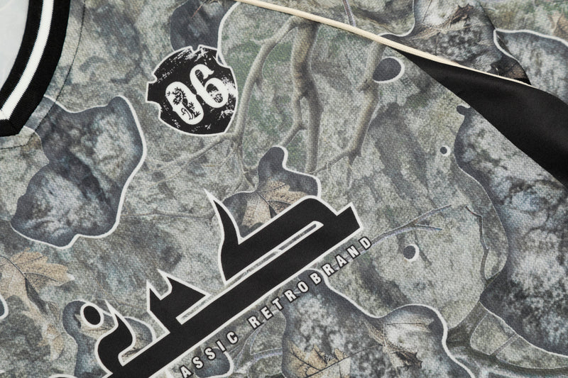 Close-up of jersey chest print with camouflage pattern, black graphic number 06 and V-neck trim