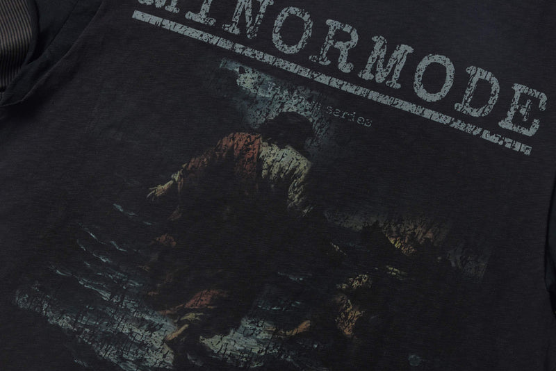 Washed black distressed graphic tee with faded vintage print and layered oversized lettering