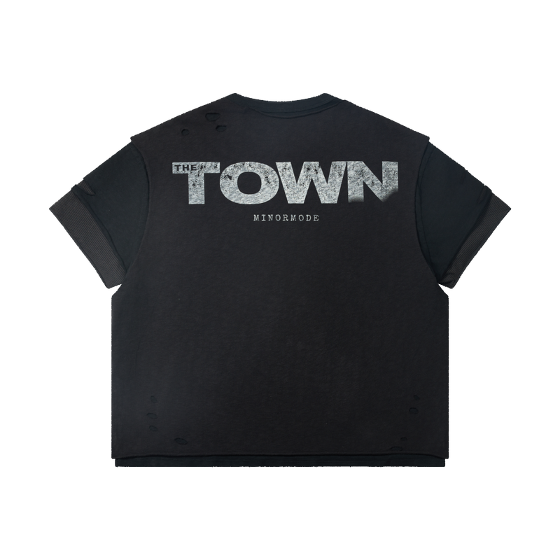 Washed black distressed graphic tee with layered sleeves and bold THE TOWN print on the back