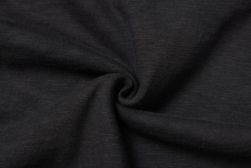 Close-up of washed black distressed graphic tee fabric with soft layered folds and ribbed knit texture